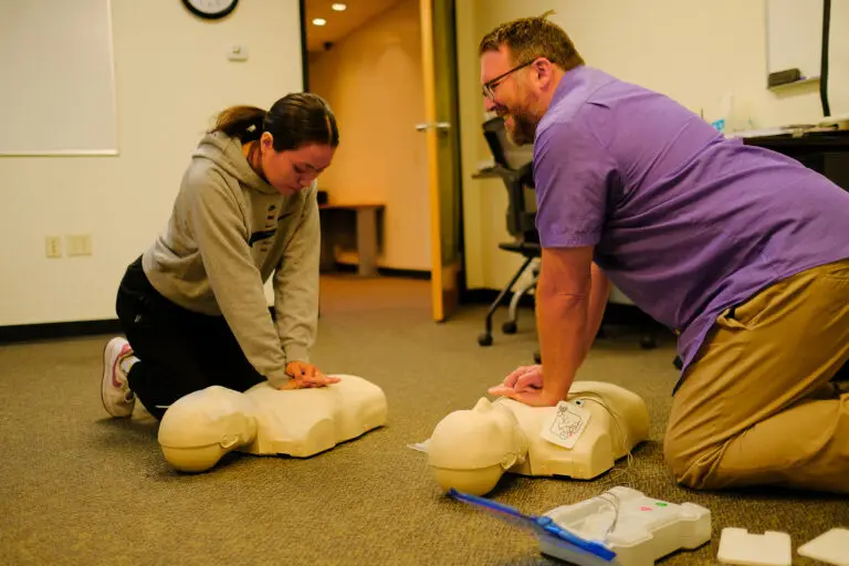 QC Behavior Health Coordinator Brandon Gill teaching CPR technique to a new employ.