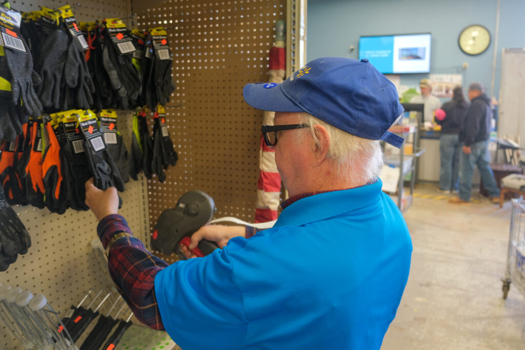 Member of QC Work Crew puts price stickers on work gloves at Re:Store in Flagstaff.