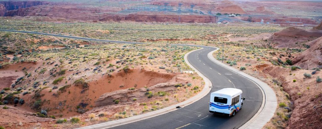 Page transit system bus shown on the road surrounded by the northern Arizona desert.