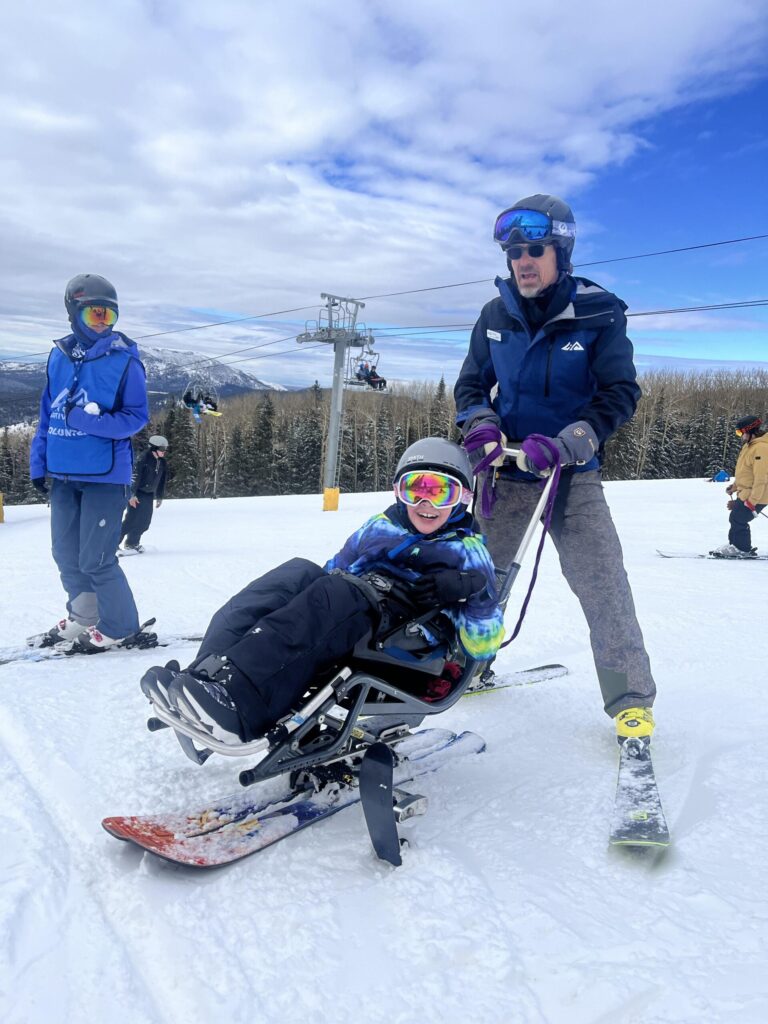 Individuals with disabilities using adaptive ski equipment.
